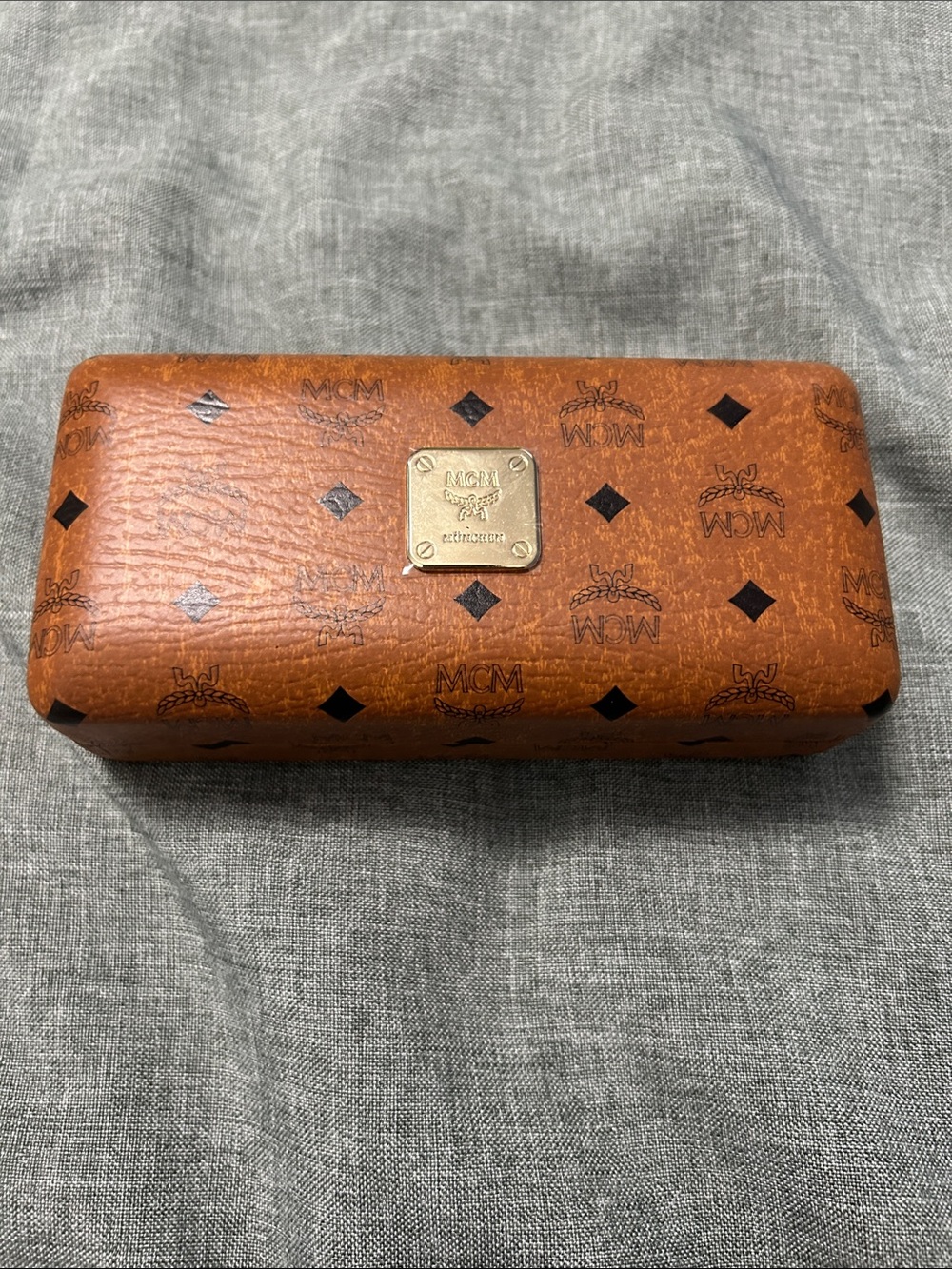 MCM cognac leatherette sunglasses case features a gold-tone logo plaque